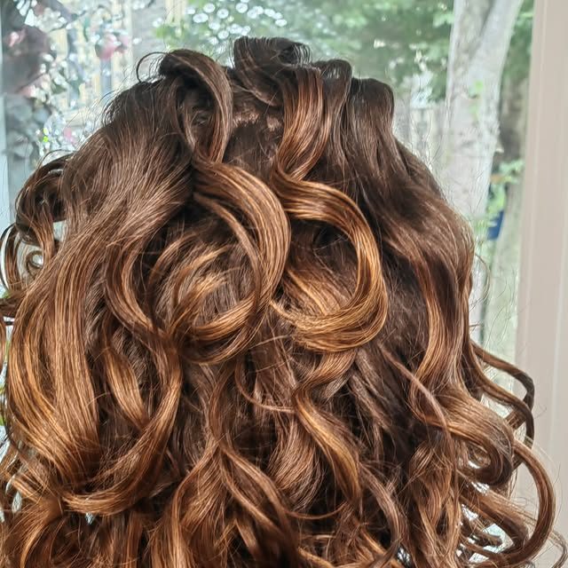 Brunette curls with caramel tones after a curly and wavy restyle